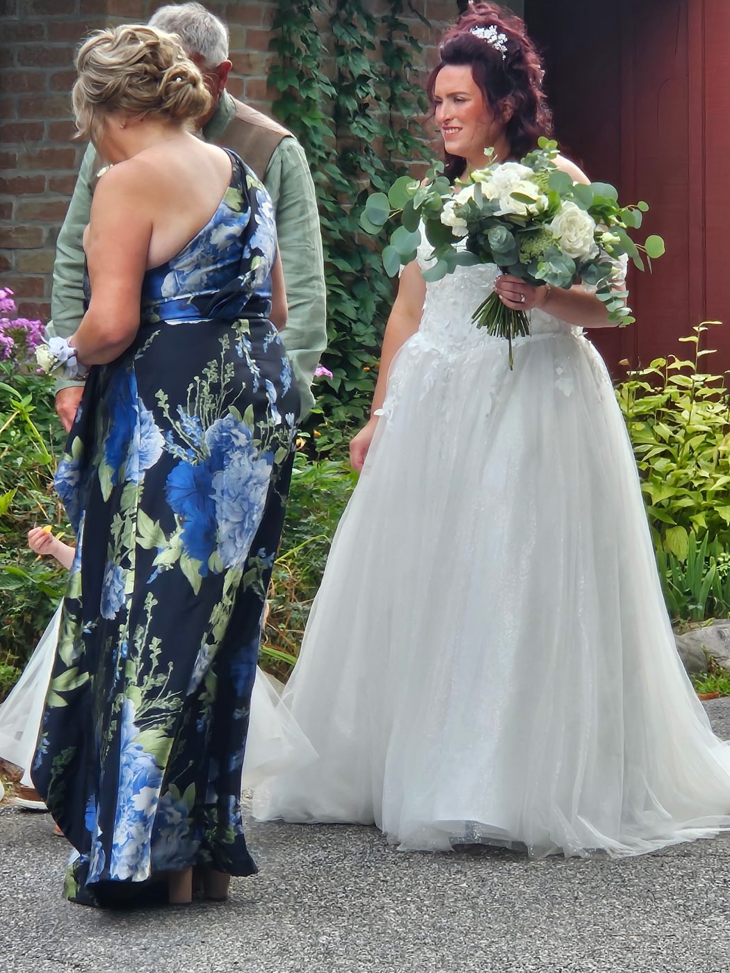 Bride and mother of the bride, both with styled updos, outside the ceremony