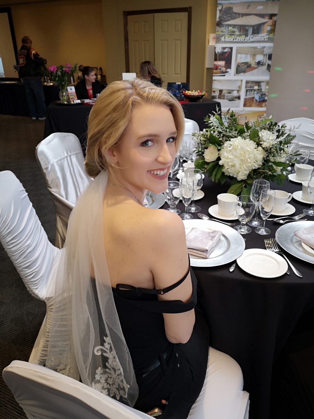 Bride with a soft blonde updo and veil at the reception