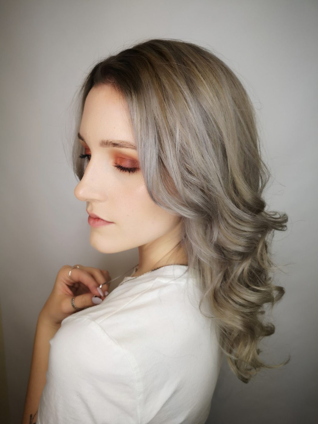 Client with ash-blonde hair styled in soft waves