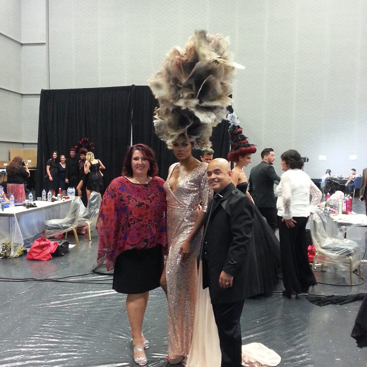 Anna backstage at a hair show beside a model in an avant-garde hairpiece