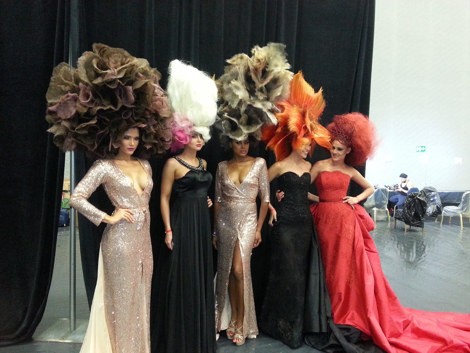 Five models backstage in avant-garde competition hairpieces and gowns